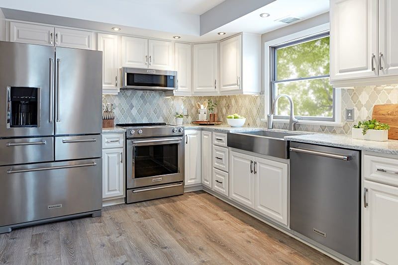 Renovated kitchen with custom cabinetry and stone countertops