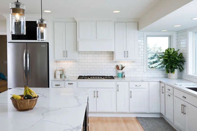 White kitchen remodel with shaker cabinets and pendant lights